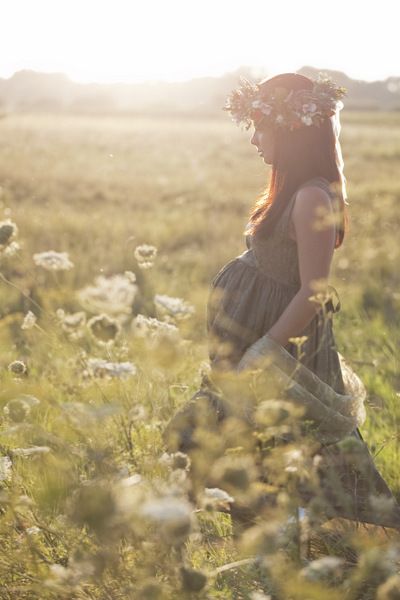 jolie jeune femme enceinte robe verte et couronne de fleurs